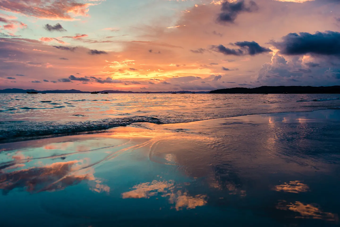 A sunset over the ocean with clouds in the sky.